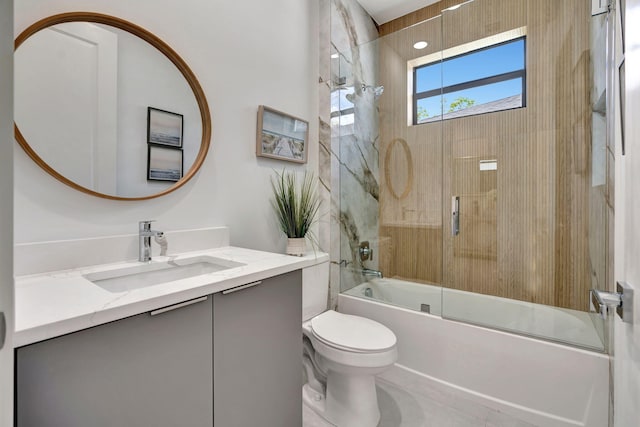 bathroom with vanity, toilet, and shower / bath combination with glass door