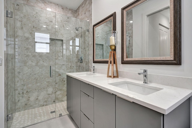 bathroom featuring double vanity, a sink, and a stall shower