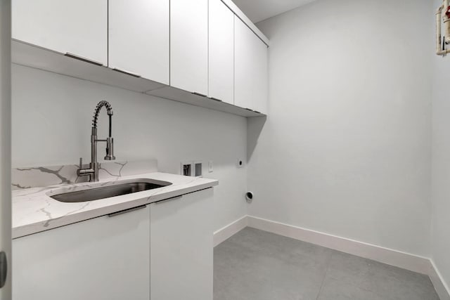 laundry room featuring a sink, baseboards, hookup for a washing machine, and cabinet space