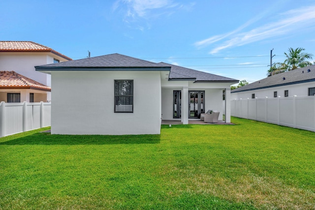back of property with a yard, a patio, a fenced backyard, and stucco siding