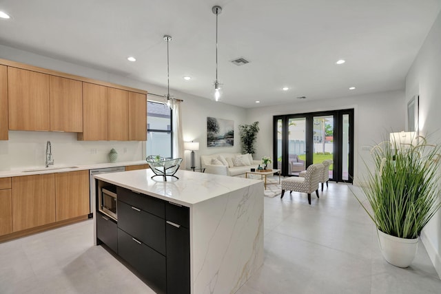 kitchen featuring a sink, a healthy amount of sunlight, modern cabinets, and visible vents