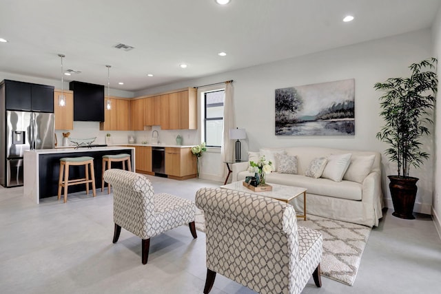 living area with recessed lighting, concrete flooring, and visible vents