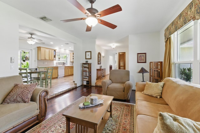 living area featuring a ceiling fan, visible vents, and dark wood-style floors