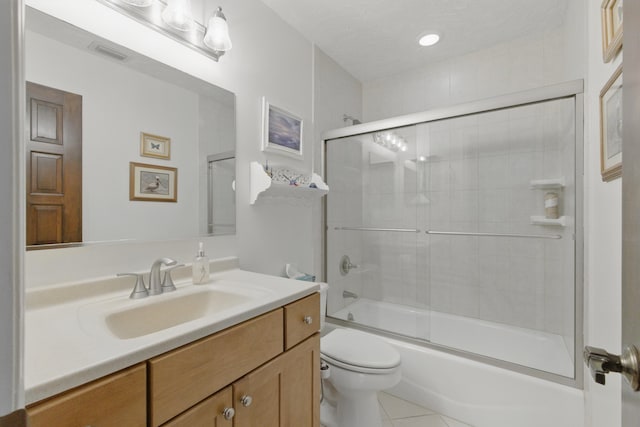 full bath featuring toilet, tile patterned floors, visible vents, bath / shower combo with glass door, and vanity