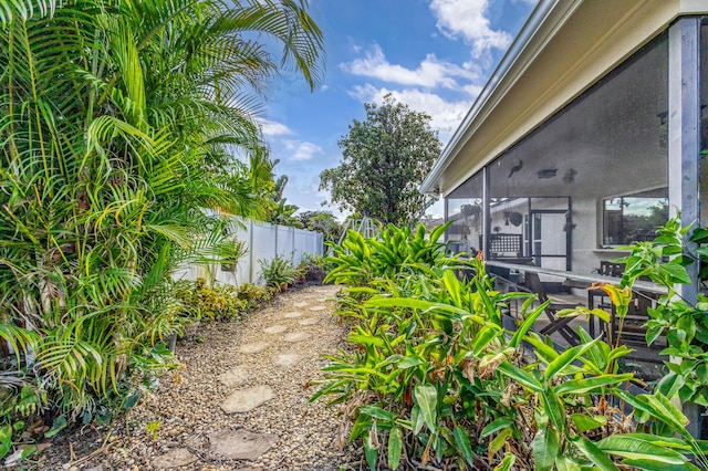 view of yard featuring a sunroom and fence