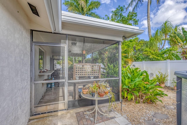 view of patio / terrace with a sunroom and fence