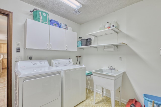 laundry room featuring cabinet space, a textured ceiling, visible vents, light floors, and independent washer and dryer