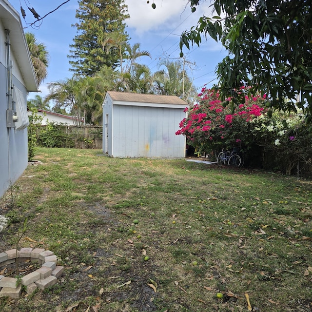 view of yard with an outdoor structure, fence, and a shed