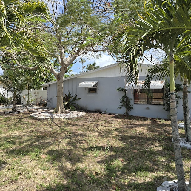 view of property exterior featuring stucco siding and fence