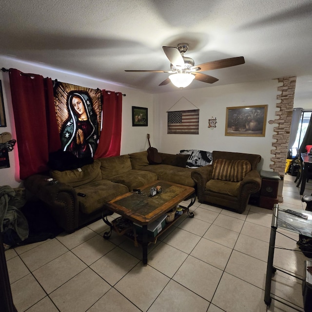living area with a textured ceiling, ceiling fan, and light tile patterned floors