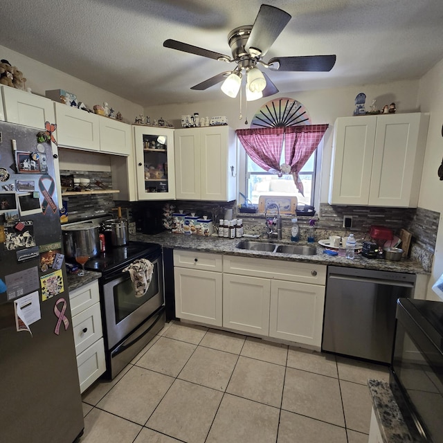 kitchen featuring decorative backsplash, a ceiling fan, white cabinetry, a sink, and stainless steel appliances