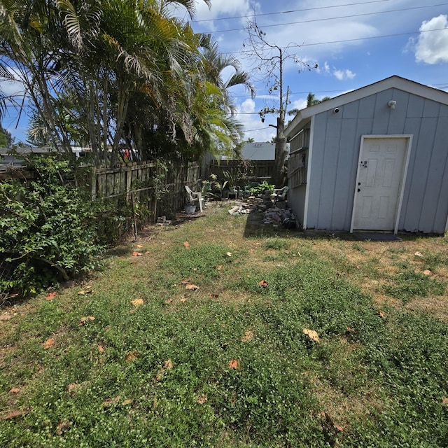view of yard with fence and an outbuilding