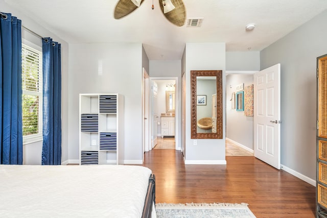 bedroom with wood finished floors, baseboards, and a heating unit