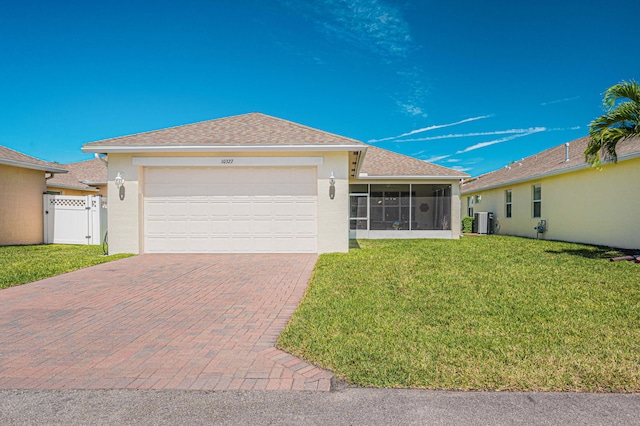 10327 SW W Park Ave, Port Saint Lucie, FL 34987 - ranch-style home with a sunroom, stucco siding, a garage, central AC, and decorative driveway