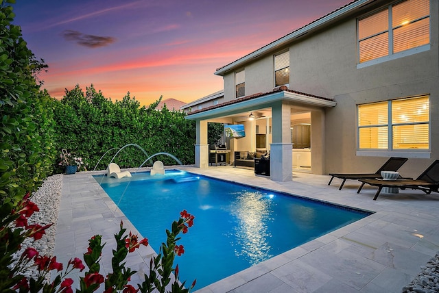 pool featuring an outdoor kitchen, a patio, and ceiling fan