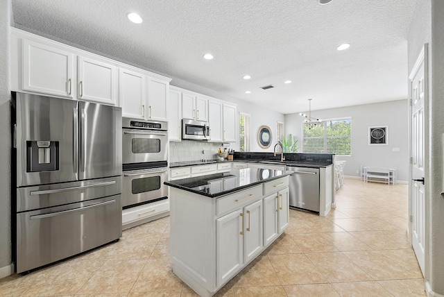 5769 SE Crooked Oak Ave, Hobe Sound, FL 33455 - kitchen with appliances with stainless steel finishes, a peninsula, a center island, a sink, and white cabinetry