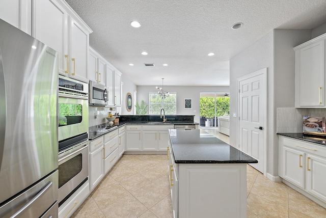 5769 SE Crooked Oak Ave, Hobe Sound, FL 33455 - kitchen featuring appliances with stainless steel finishes, a sink, white cabinets, a textured ceiling, and recessed lighting