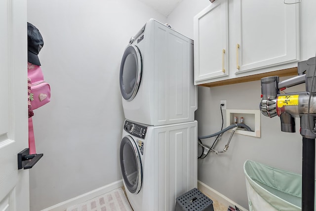 5769 SE Crooked Oak Ave, Hobe Sound, FL 33455 - laundry room featuring estacked washer and dryer, baseboards, and cabinet space