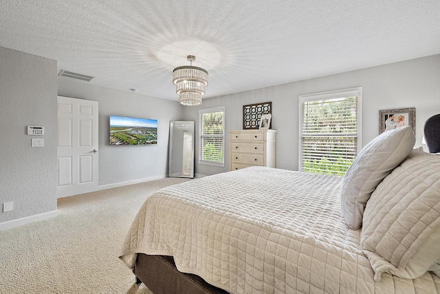 5769 SE Crooked Oak Ave, Hobe Sound, FL 33455 - carpeted bedroom with baseboards, a chandelier, a textured wall, and a textured ceiling