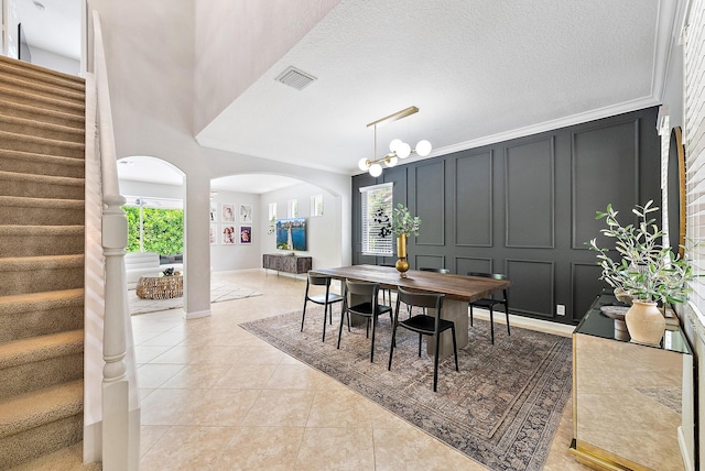 5769 SE Crooked Oak Ave, Hobe Sound, FL 33455 - dining room featuring stairs, arched walkways, light tile patterned floors, and a decorative wall