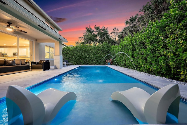 pool at dusk with a fenced in pool, a ceiling fan, an outdoor hangout area, and a patio