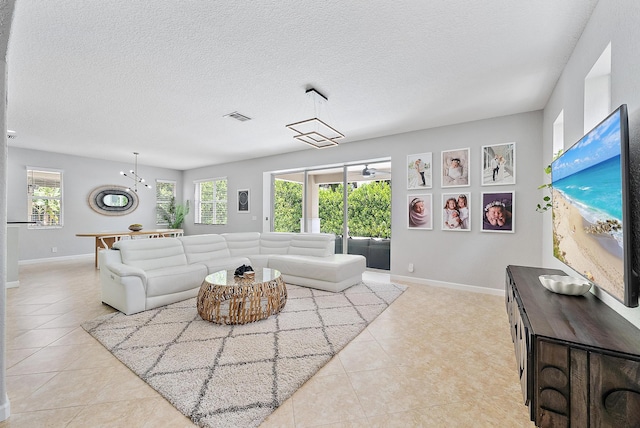 5769 SE Crooked Oak Ave, Hobe Sound, FL 33455 - living area featuring baseboards, light tile patterned flooring, and a textured ceiling