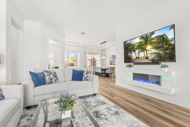 132 Steeple Cir, Jupiter, FL 33458 - living area with wood finished floors, baseboards, a glass covered fireplace, and crown molding