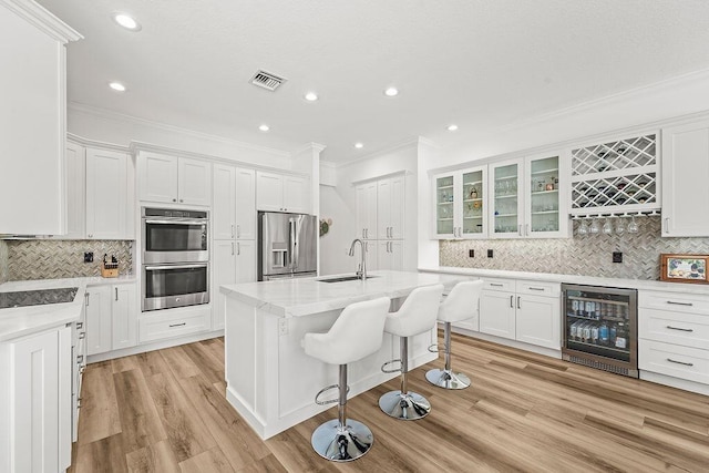 132 Steeple Cir, Jupiter, FL 33458 - kitchen with stainless steel appliances, wine cooler, a sink, crown molding, and tasteful backsplash