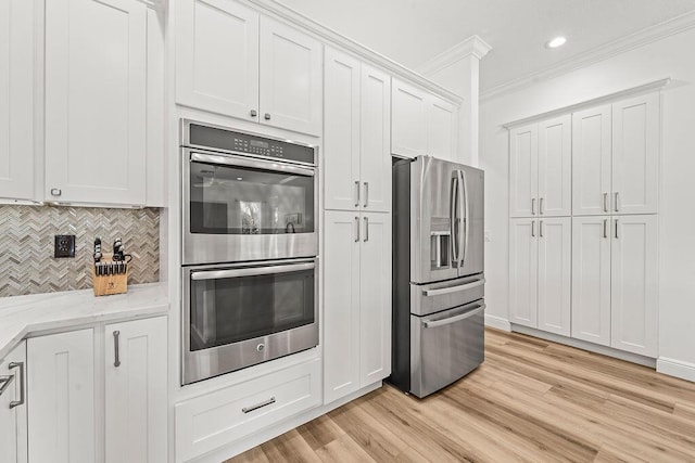 132 Steeple Cir, Jupiter, FL 33458 - kitchen featuring stainless steel appliances, crown molding, tasteful backsplash, light stone countertops, and light wood finished floors