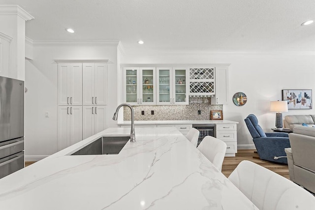 132 Steeple Cir, Jupiter, FL 33458 - kitchen with a sink, crown molding, freestanding refrigerator, dark wood finished floors, and white cabinetry