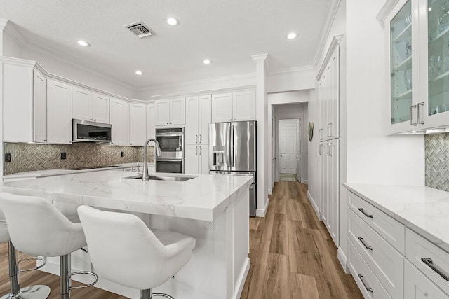 132 Steeple Cir, Jupiter, FL 33458 - kitchen with stainless steel appliances, white cabinets, a sink, crown molding, and glass insert cabinets