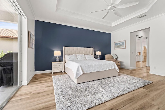 132 Steeple Cir, Jupiter, FL 33458 - bedroom with a raised ceiling, light wood-style flooring, baseboards, ornamental molding, and a ceiling fan