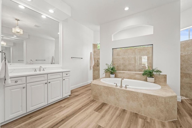 132 Steeple Cir, Jupiter, FL 33458 - bathroom featuring vanity, a bath, wood finished floors, recessed lighting, and baseboards