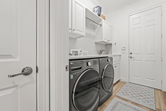 132 Steeple Cir, Jupiter, FL 33458 - laundry area featuring separate washer and dryer, cabinet space, light wood-style flooring, and ornamental molding