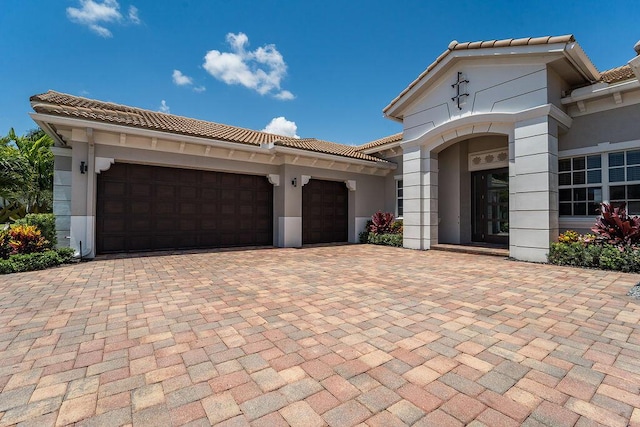 132 Steeple Cir, Jupiter, FL 33458 - view of front facade with a tiled roof, decorative driveway, a garage, and stucco siding
