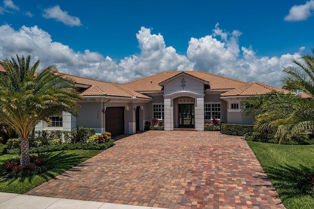 132 Steeple Cir, Jupiter, FL 33458 - mediterranean / spanish home featuring a garage, decorative driveway, a tile roof, and stucco siding