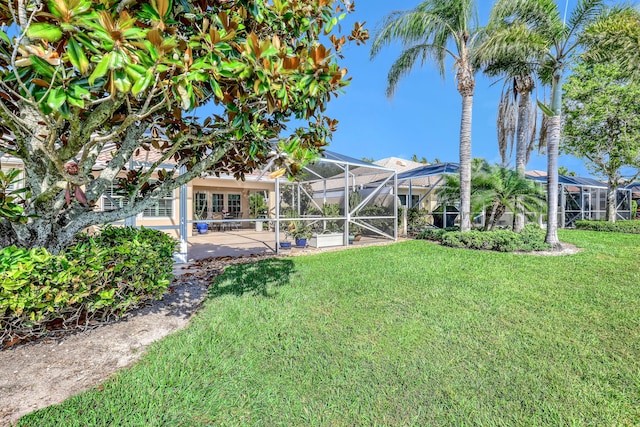 view of yard with glass enclosure and a patio area