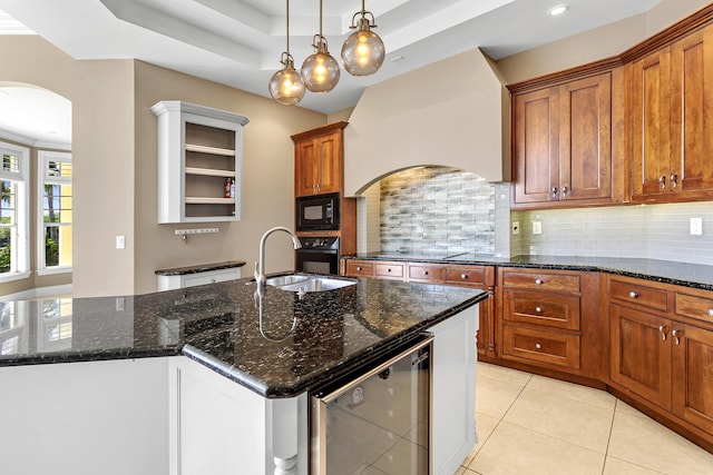 kitchen with arched walkways, black appliances, tasteful backsplash, brown cabinetry, and premium range hood
