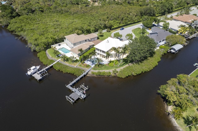 aerial view of property's location with a large body of water and a forest