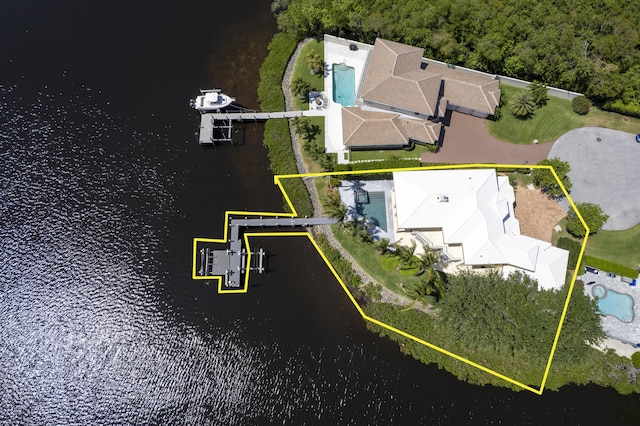 aerial view of property's location with a pool area, property parcel outlined, and a nearby body of water
