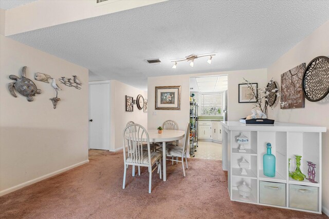 18081 SE Country Club Dr Unit 130, Jupiter, FL 33469 - dining area with light colored carpet, a textured ceiling, and baseboards