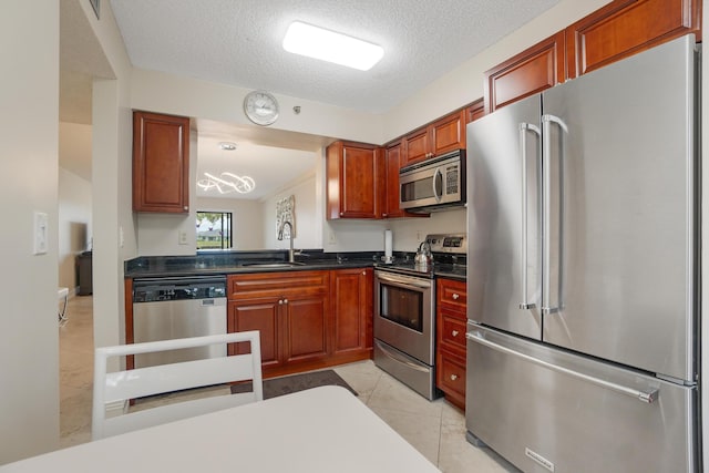 7240 Huntington Ln Unit 105, Delray Beach, FL 33446 - kitchen featuring light tile patterned floors, a sink, dark countertops, stainless steel appliances, and a textured ceiling