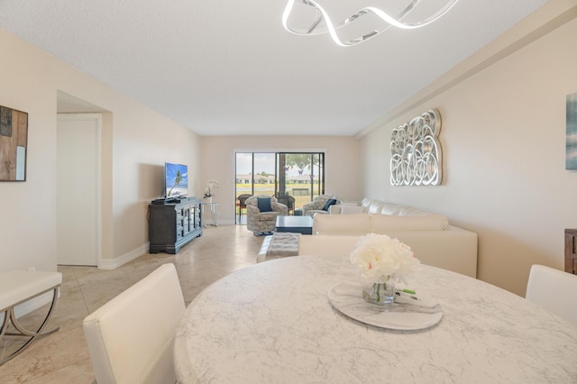 7240 Huntington Ln Unit 105, Delray Beach, FL 33446 - dining space with a notable chandelier, baseboards, and light tile patterned floors