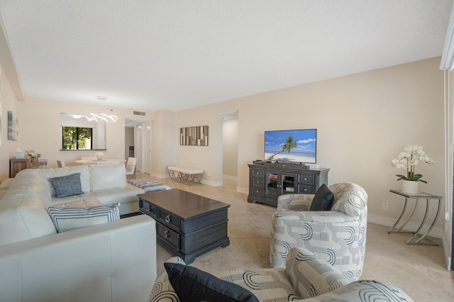 7240 Huntington Ln Unit 105, Delray Beach, FL 33446 - living room featuring baseboards, a notable chandelier, light tile patterned floors, and visible vents