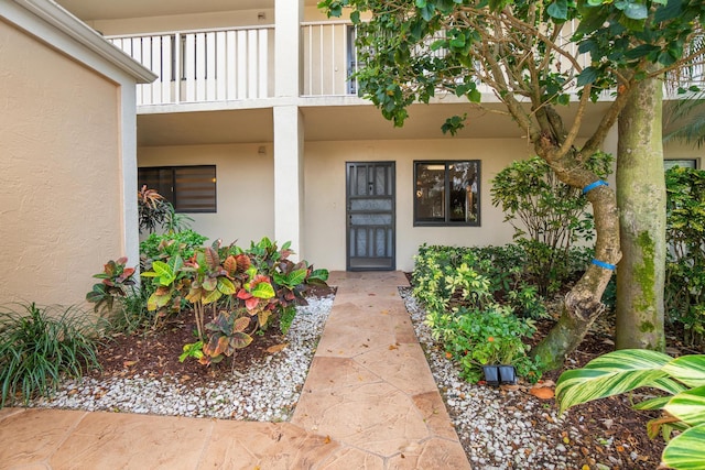 7240 Huntington Ln Unit 105, Delray Beach, FL 33446 - doorway to property featuring a balcony and stucco siding