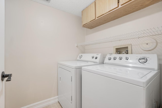7240 Huntington Ln Unit 105, Delray Beach, FL 33446 - clothes washing area with cabinet space, washing machine and clothes dryer, a textured ceiling, and baseboards