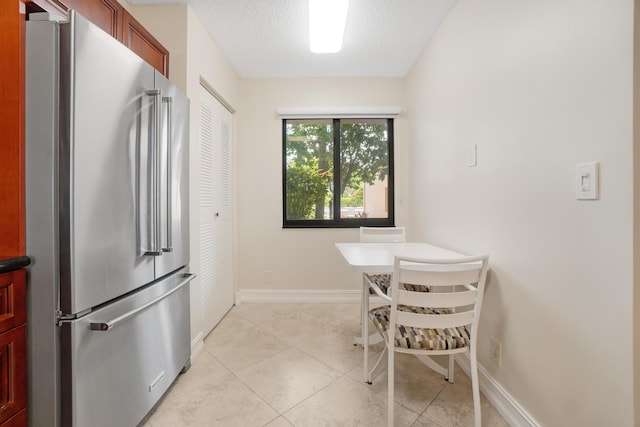 7240 Huntington Ln Unit 105, Delray Beach, FL 33446 - dining area with light tile patterned floors, baseboards, and a textured ceiling