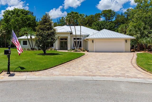 8005 SW Yachtsmans Dr, Stuart, FL 34997 - view of front of house featuring french doors, stucco siding, decorative driveway, an attached garage, and a front yard