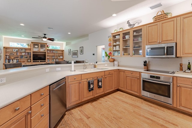 8005 SW Yachtsmans Dr, Stuart, FL 34997 - kitchen featuring stainless steel appliances, a sink, light wood-type flooring, a ceiling fan, and glass insert cabinets