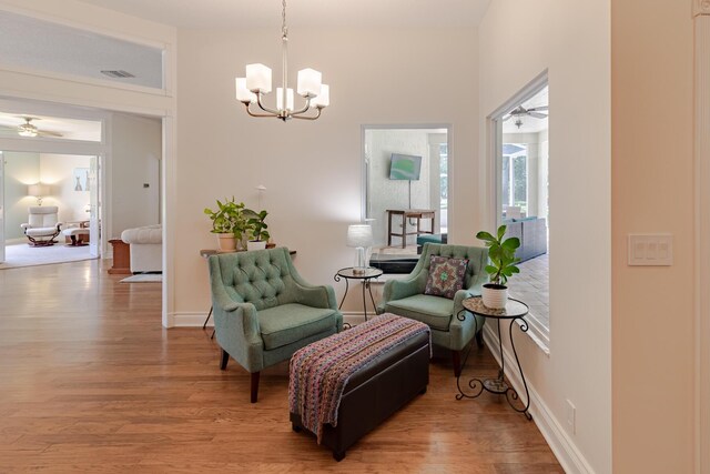 8005 SW Yachtsmans Dr, Stuart, FL 34997 - sitting room featuring a chandelier, light wood-style flooring, a ceiling fan, and healthy amount of natural light